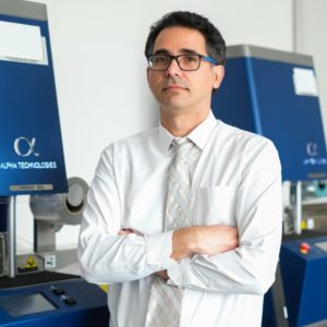 A person standing in a lab with his arms crossed